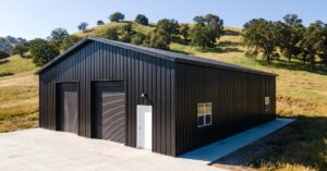 A black metal pole building stands on a rural property with open land surrounding the completed structure.